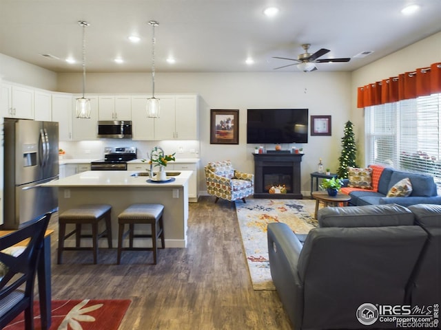 living room with dark wood-type flooring and ceiling fan