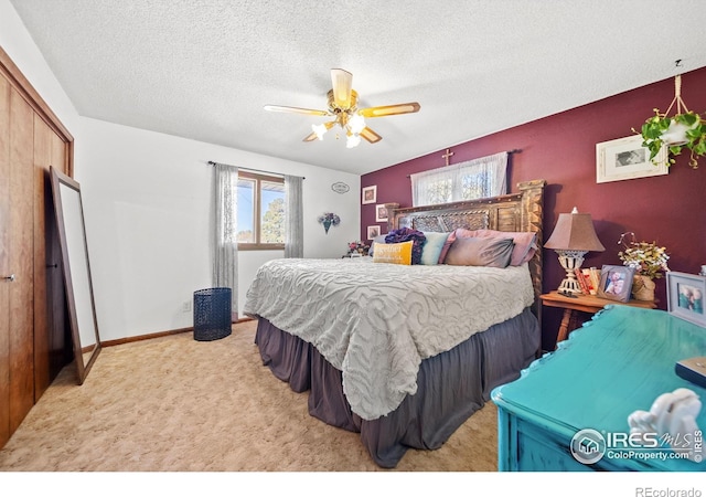 bedroom featuring light carpet, a textured ceiling, a closet, and ceiling fan