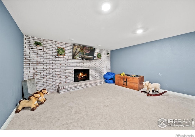 game room with brick wall, a fireplace, and carpet floors