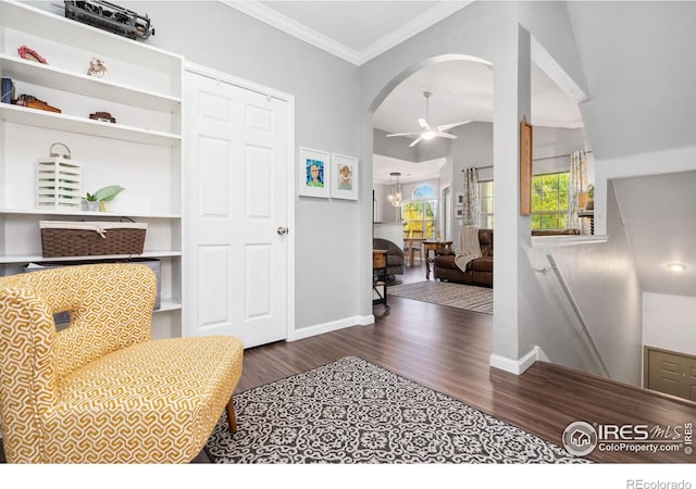 living area featuring dark wood-type flooring, ceiling fan, crown molding, and vaulted ceiling