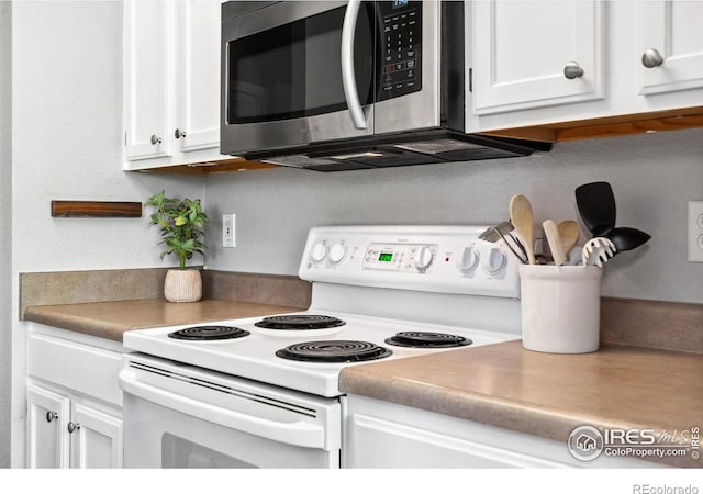 kitchen featuring white electric range oven and white cabinets