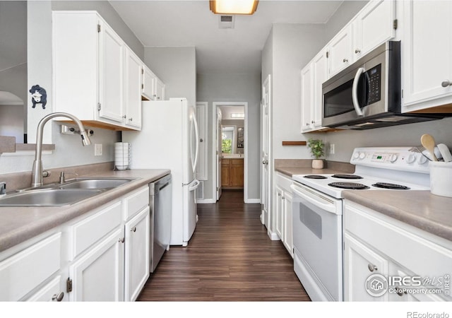 kitchen with dark wood-type flooring, stainless steel appliances, sink, and white cabinets