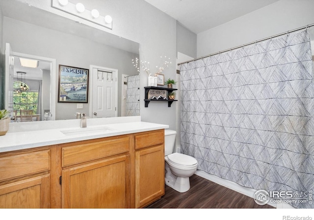 bathroom with vanity, hardwood / wood-style floors, a shower with shower curtain, and toilet