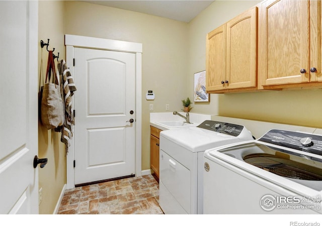 clothes washing area featuring cabinets, independent washer and dryer, and sink