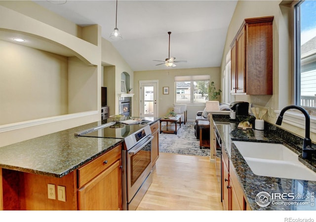 kitchen with lofted ceiling, sink, dark stone counters, and electric stove