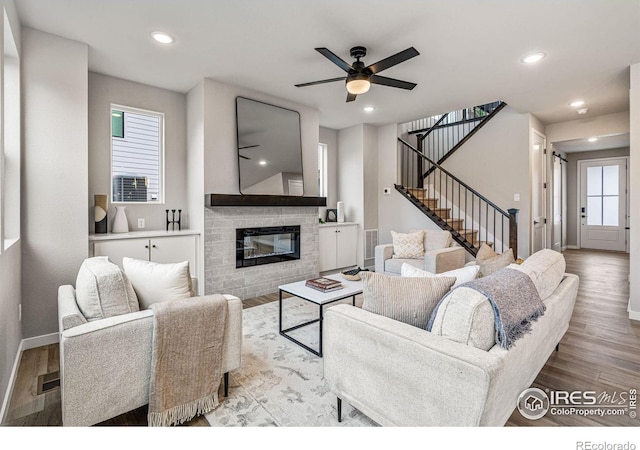 living room featuring ceiling fan, light wood-type flooring, and plenty of natural light