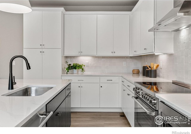 kitchen with wall chimney exhaust hood, appliances with stainless steel finishes, and white cabinetry