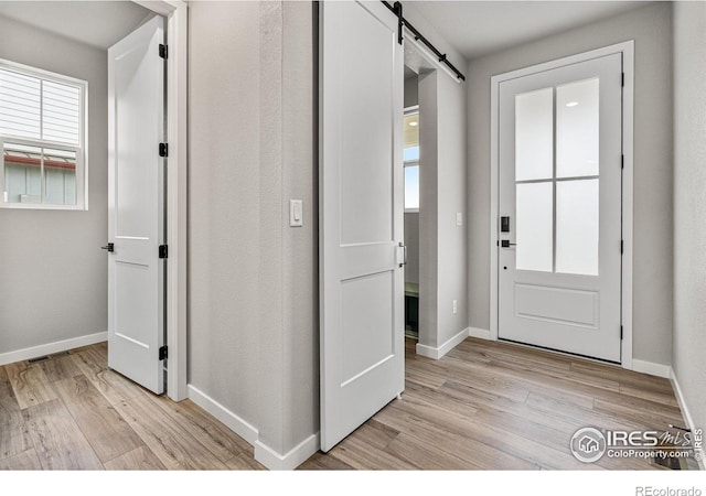 entrance foyer with light hardwood / wood-style flooring and a barn door