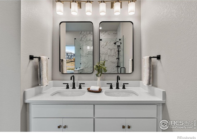 bathroom featuring a shower with door and vanity