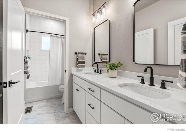 full bathroom featuring vanity, shower / bath combination with curtain, and toilet