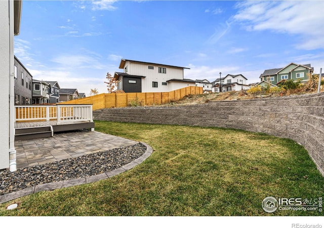 view of yard featuring a wooden deck and a patio