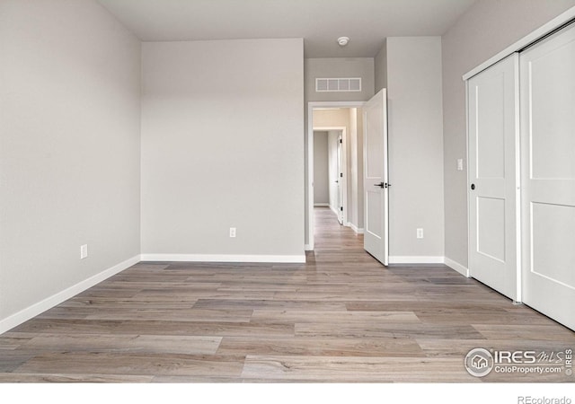 unfurnished bedroom with a closet and light hardwood / wood-style flooring