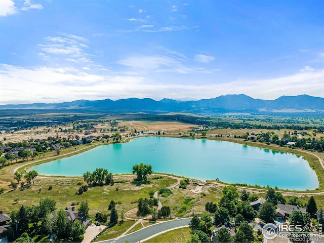 drone / aerial view featuring a water and mountain view