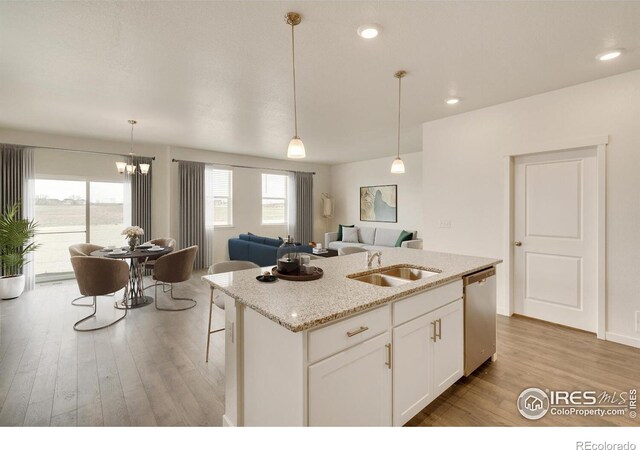 kitchen featuring a sink, stainless steel dishwasher, light wood-type flooring, open floor plan, and recessed lighting