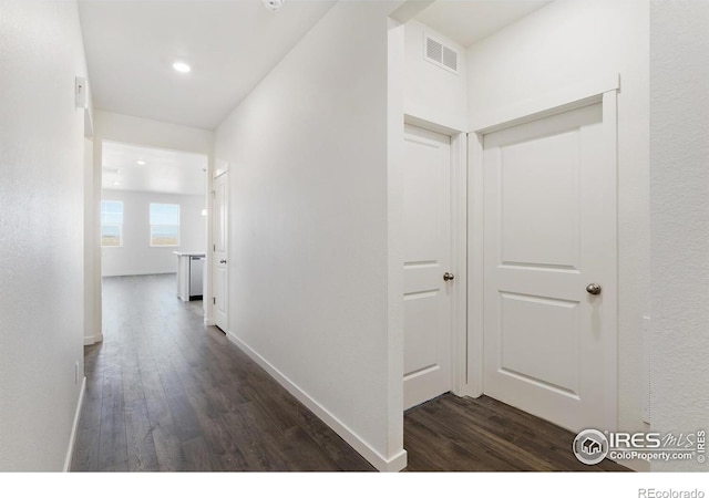 hall featuring dark wood-style floors, baseboards, and recessed lighting