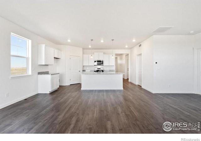 kitchen featuring appliances with stainless steel finishes, white cabinets, a kitchen island with sink, and dark hardwood / wood-style floors