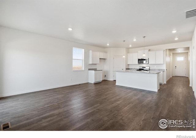 kitchen featuring stainless steel appliances, recessed lighting, dark wood finished floors, a kitchen island with sink, and white cabinets