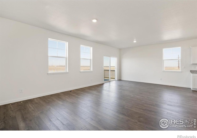 unfurnished room featuring dark wood-style flooring, baseboards, and recessed lighting