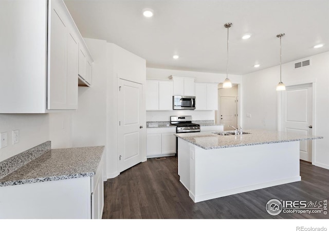 kitchen featuring appliances with stainless steel finishes, a sink, dark wood-type flooring, white cabinets, and recessed lighting
