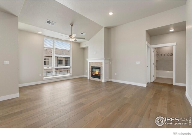 968 Birdwhistle Ln Unit 12, Fort Collins, CO 80524 - unfurnished living room with ceiling fan, a glass covered fireplace, light wood-type flooring, lofted ceiling, and recessed lighting