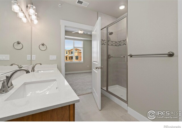 968 Birdwhistle Ln Unit 12, Fort Collins, CO 80524 - bathroom featuring a shower stall, baseboards, double vanity, and tile patterned flooring
