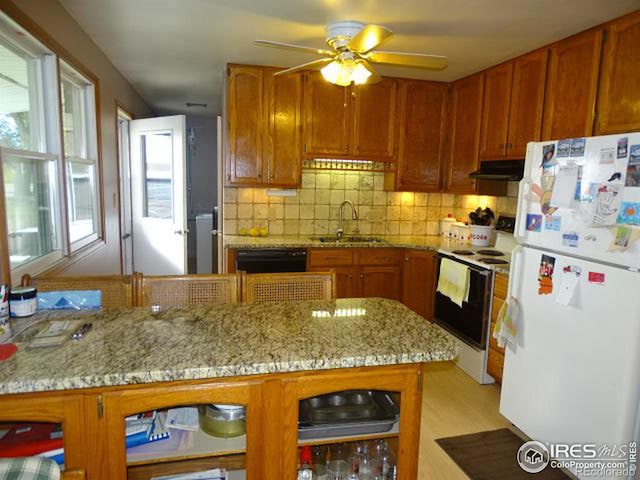 kitchen with ceiling fan, light stone countertops, light hardwood / wood-style flooring, sink, and white appliances