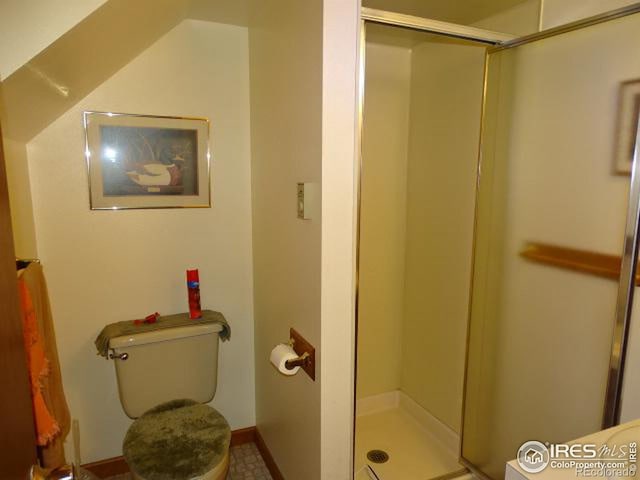 bathroom with toilet, tile patterned flooring, and a shower with door