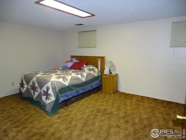 bedroom featuring a textured ceiling and carpet