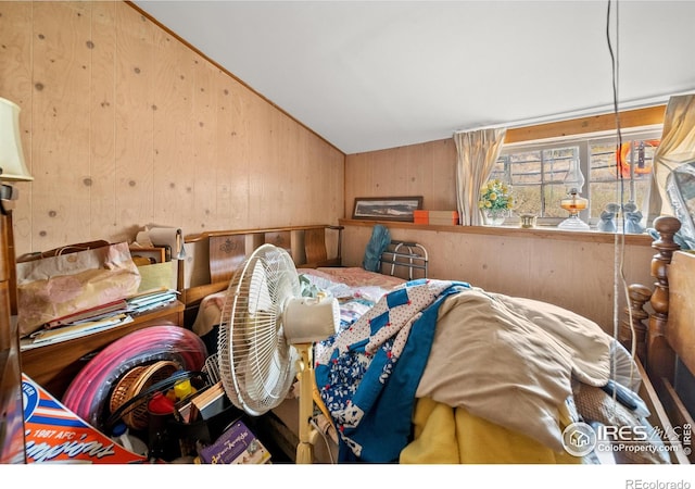 bedroom featuring wood walls and lofted ceiling