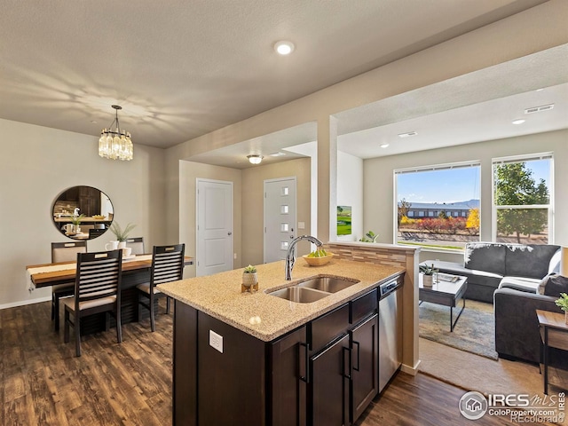 kitchen featuring sink, dishwasher, hanging light fixtures, light stone counters, and dark hardwood / wood-style floors