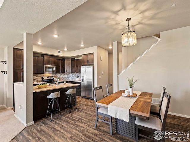 dining space with dark hardwood / wood-style floors, a chandelier, and a textured ceiling