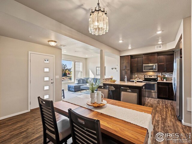 dining room featuring an inviting chandelier, a textured ceiling, and dark wood-type flooring