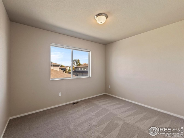 empty room featuring carpet flooring and a textured ceiling