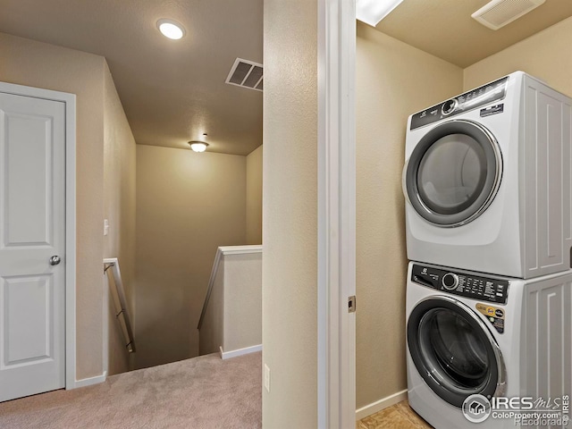 laundry area with stacked washer / dryer and light carpet