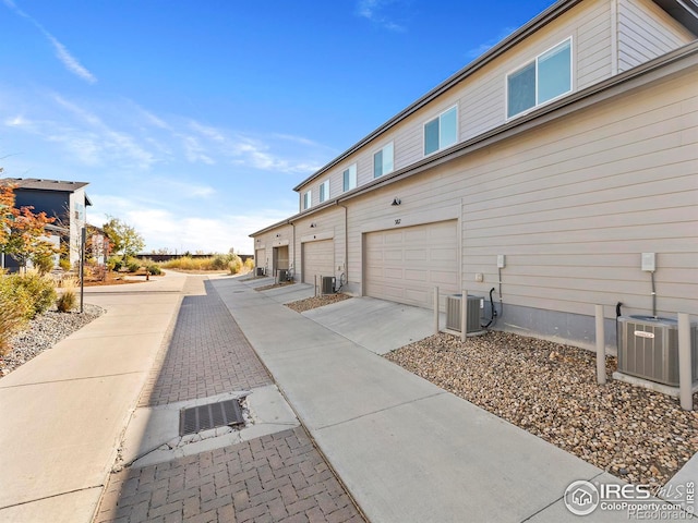 view of property exterior with central AC and a garage