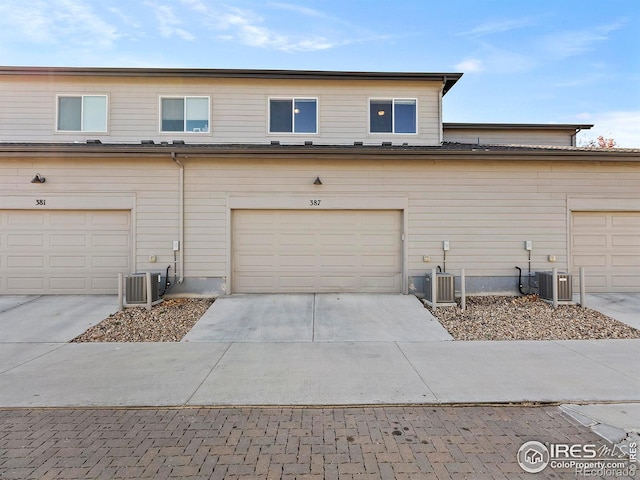 view of front of house with a garage and central air condition unit