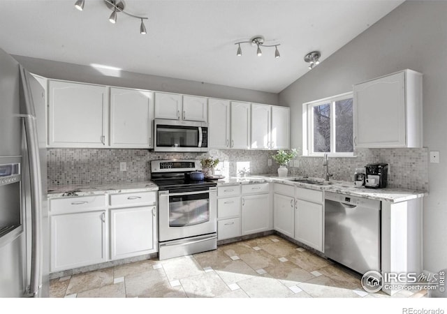 kitchen featuring vaulted ceiling, appliances with stainless steel finishes, sink, and white cabinets