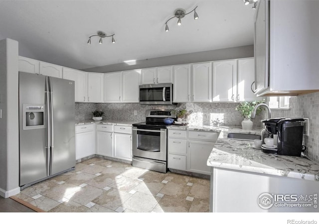 kitchen with stainless steel appliances, sink, white cabinets, and decorative backsplash