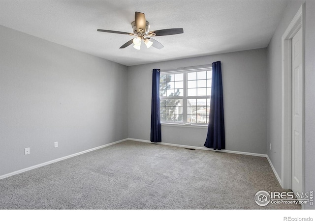 carpeted empty room featuring ceiling fan and a textured ceiling