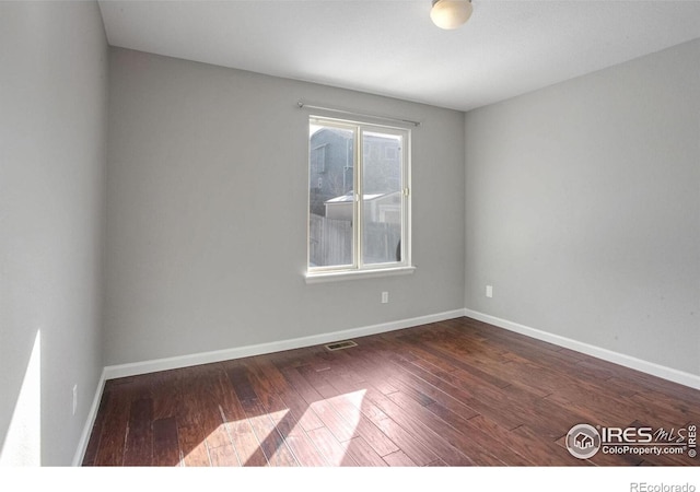 unfurnished room featuring dark hardwood / wood-style flooring