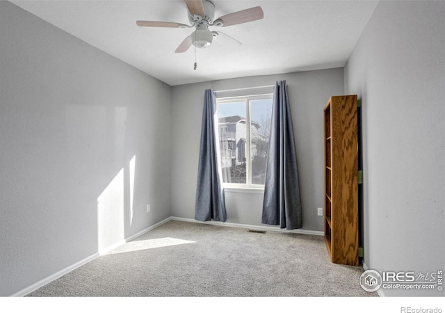 spare room with light carpet and ceiling fan