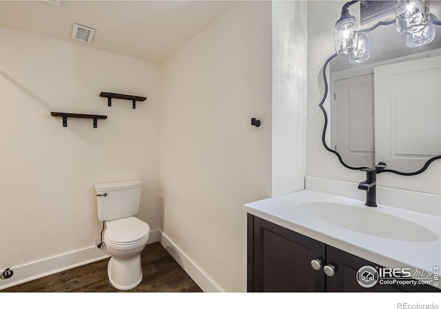 bathroom featuring toilet, vanity, and wood-type flooring