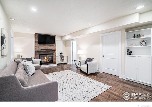 living room with dark hardwood / wood-style flooring and a fireplace