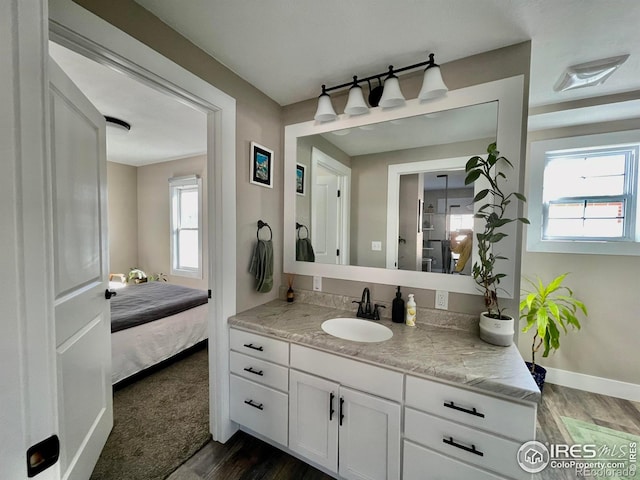 304 S High School Ave, Holyoke, CO 80734 - ensuite bathroom with wood finished floors, vanity, and plenty of natural light