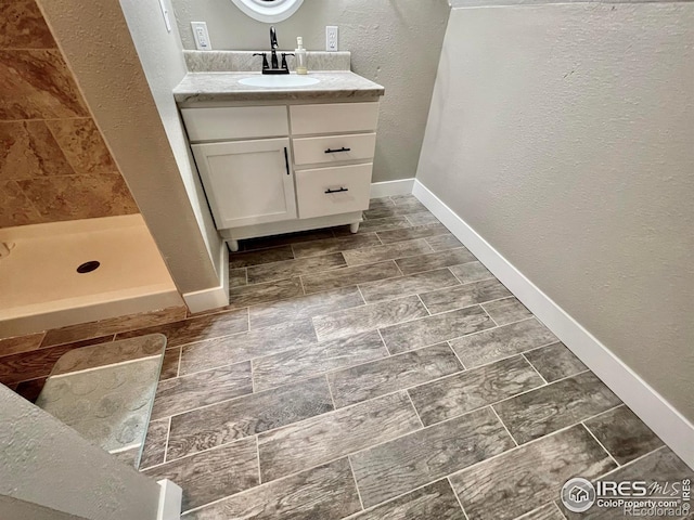 304 S High School Ave, Holyoke, CO 80734 - full bath featuring a textured wall, vanity, and a tile shower