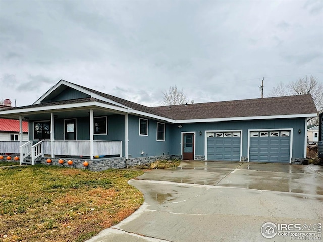 view of front of property featuring a front lawn, covered porch, and a garage