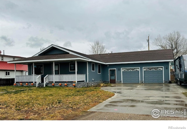 view of front of home featuring a garage, covered porch, and a front lawn