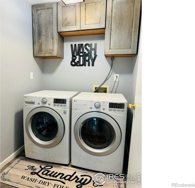 laundry room featuring cabinets and washer and clothes dryer