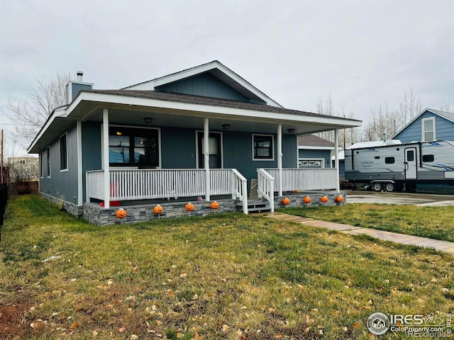 view of front facade featuring covered porch and a front yard