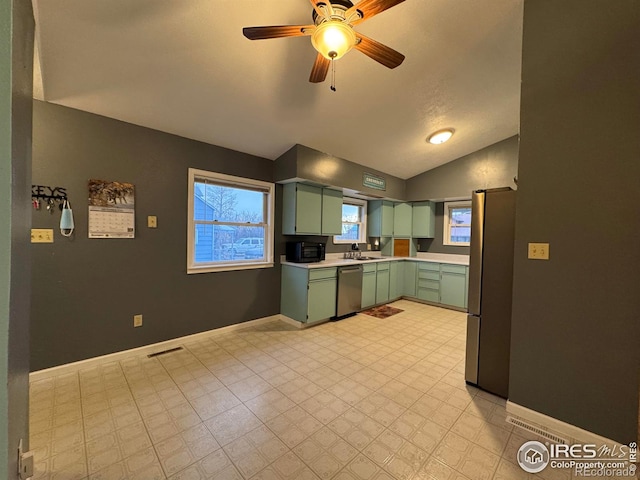 kitchen featuring appliances with stainless steel finishes, ceiling fan, sink, green cabinetry, and lofted ceiling